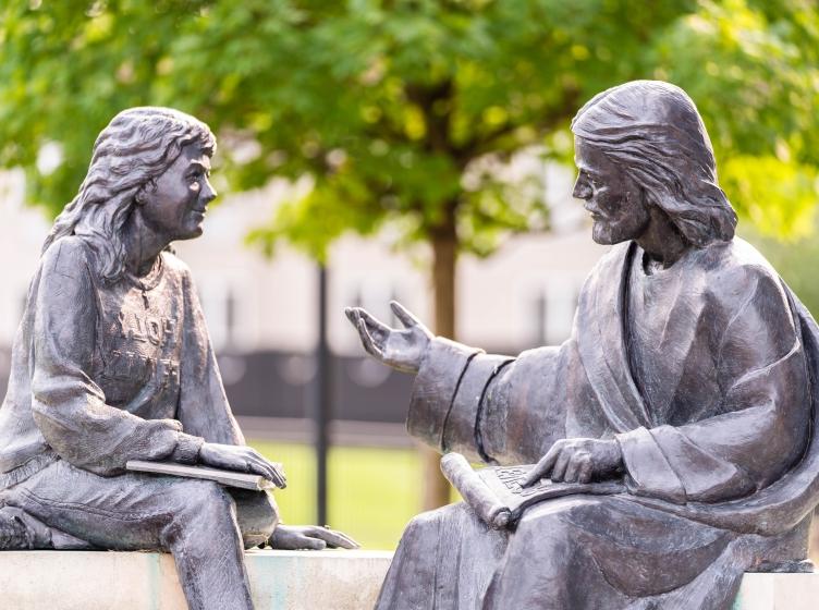 Jesus and a student on the bench statue